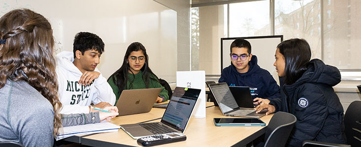Students conversing around a table for tutoring session