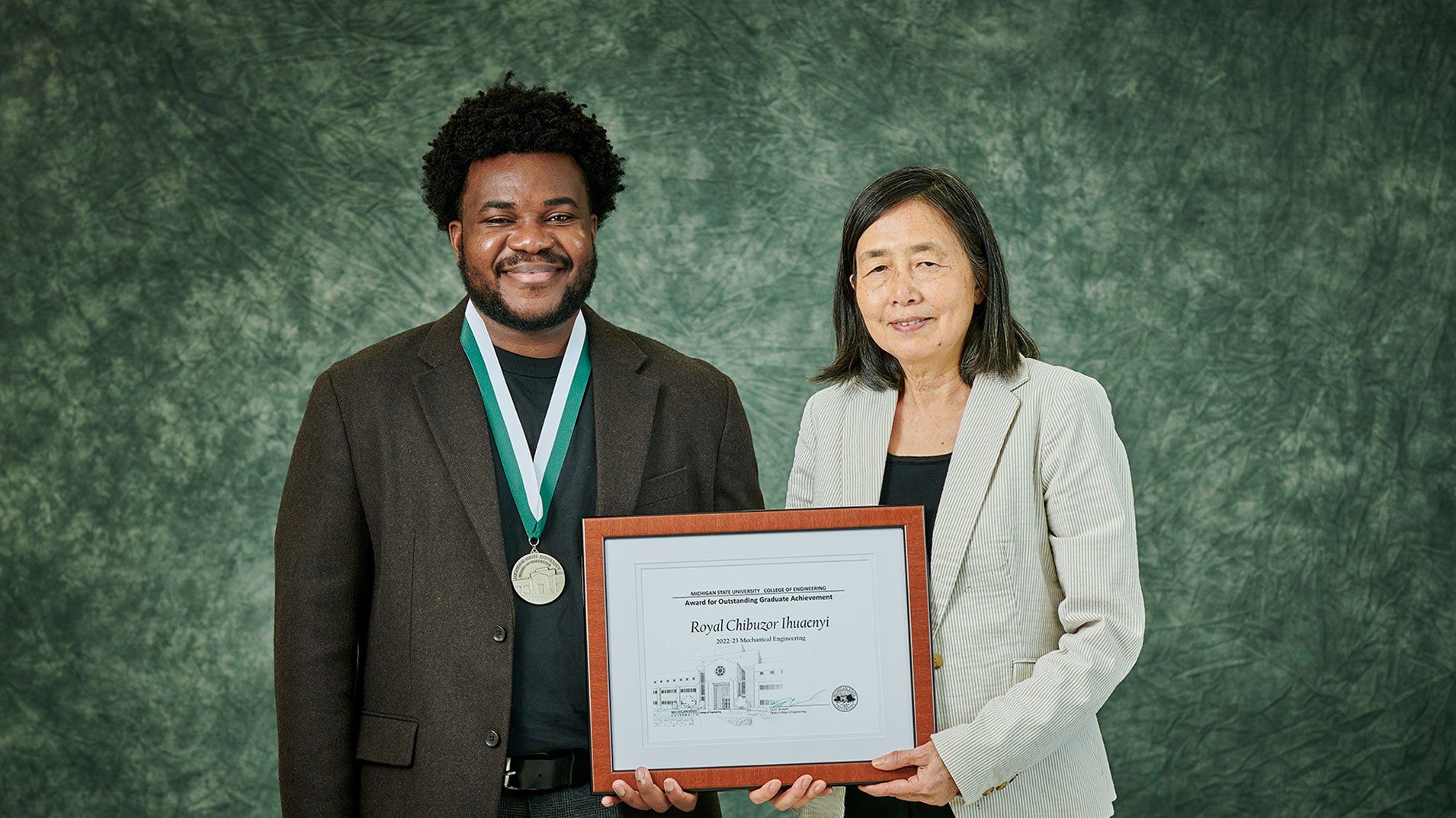 Graduate student and professor holding an awards plaque