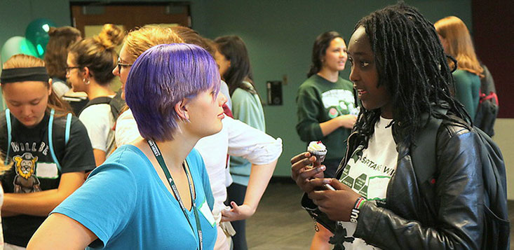 2 WIE Student Ambassadors talking during a celebration