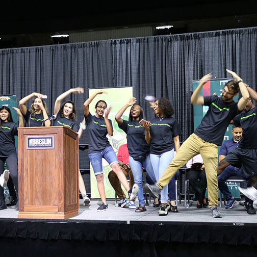 CoRe student ambassadors dancing on stage during Colloquium