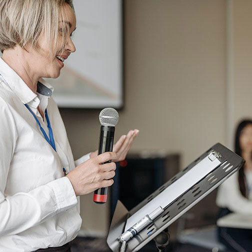 Individual speaking behind a podium during an event