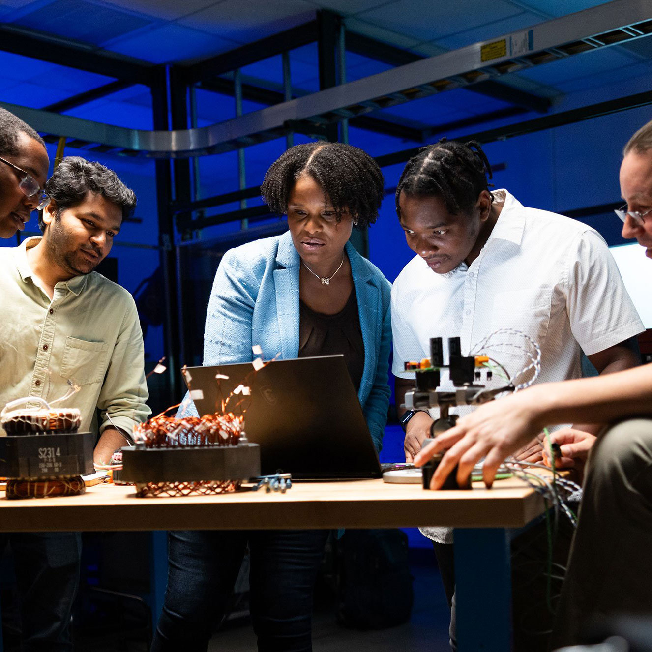 Shanelle Foster and students viewing a shared computer screen in a lab