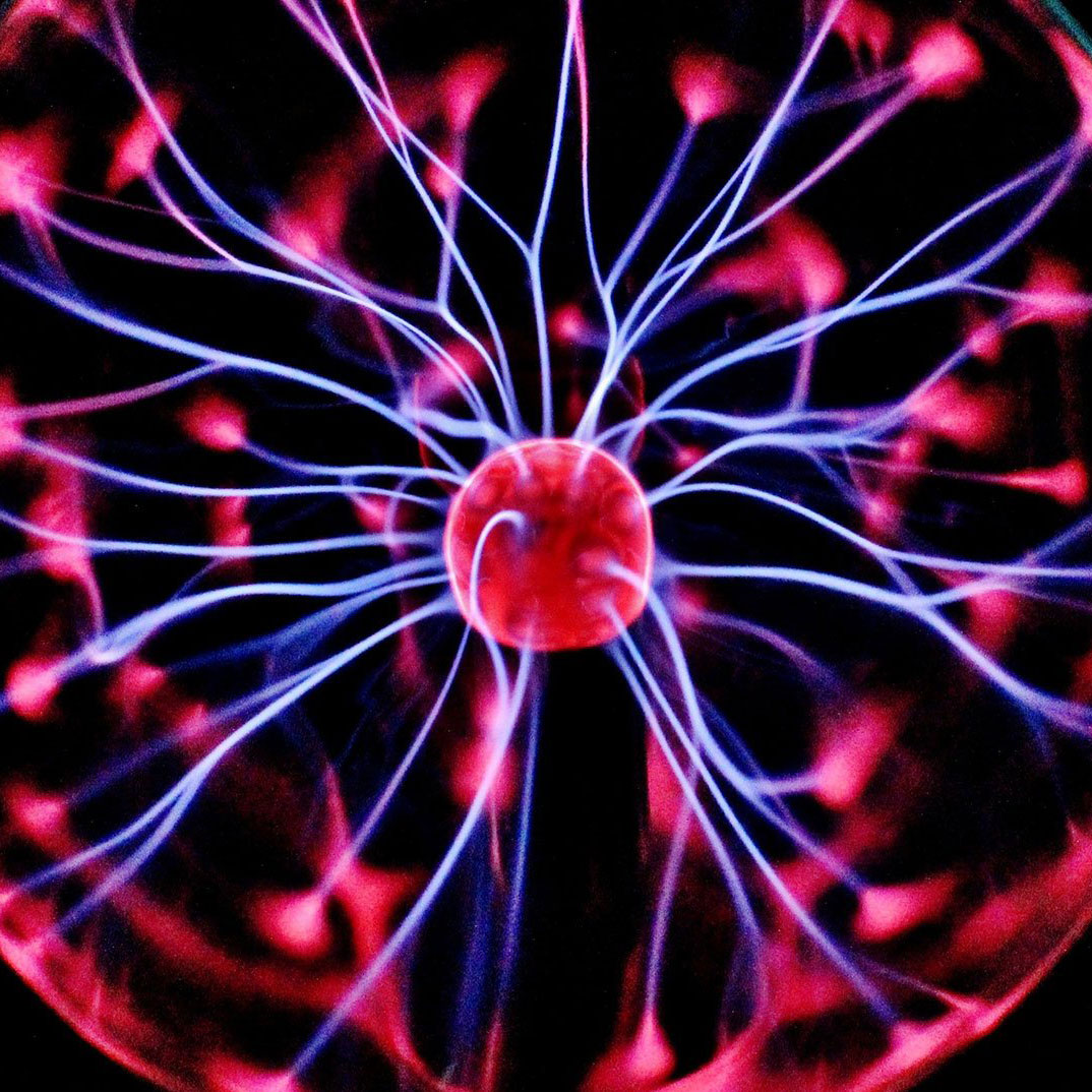 A glowing plasma globe with bright pink and blue electric filaments radiating from the center