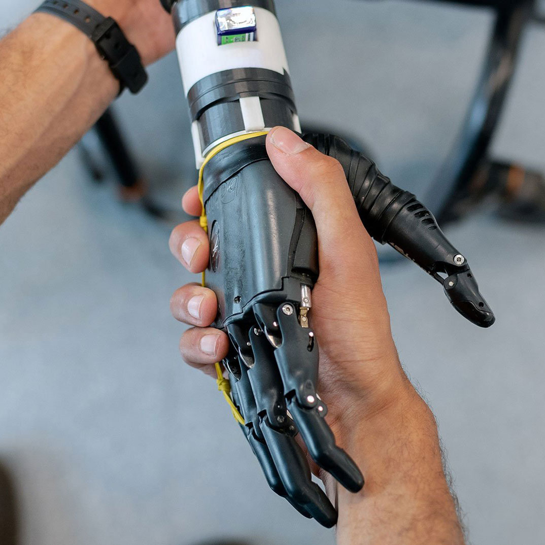 A person interacting with a robot by shaking its hand