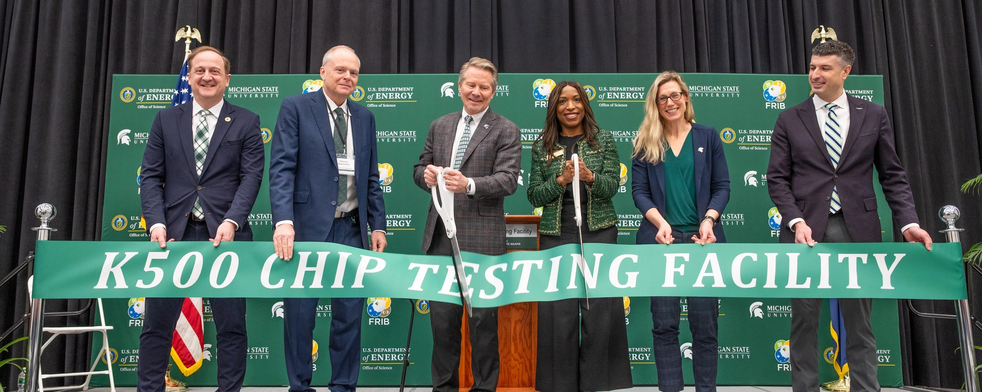 Individual's cutting the K500 Chip Testing Facility ribbon